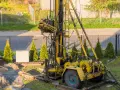 Żółta wiertnica na podwórku. Zastanawiasz się, ile kosztuje wykopanie studni głębokości 25 m?