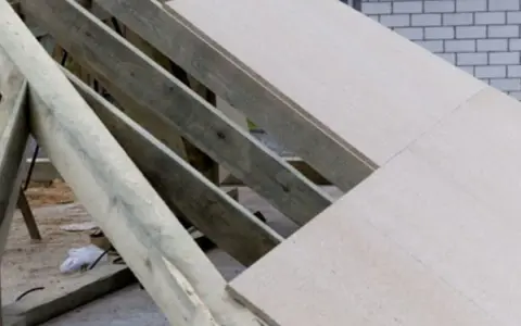 Konstrukcja dachu garażu z płyty OSB, widoczne drewniane krokwie i fragmenty pokrycia.