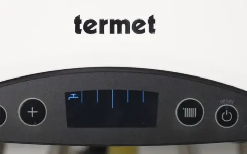 Panel sterowania pieca Termet. Ikona grzejnika sugeruje, jak przestawić piec na tryb zimowy.